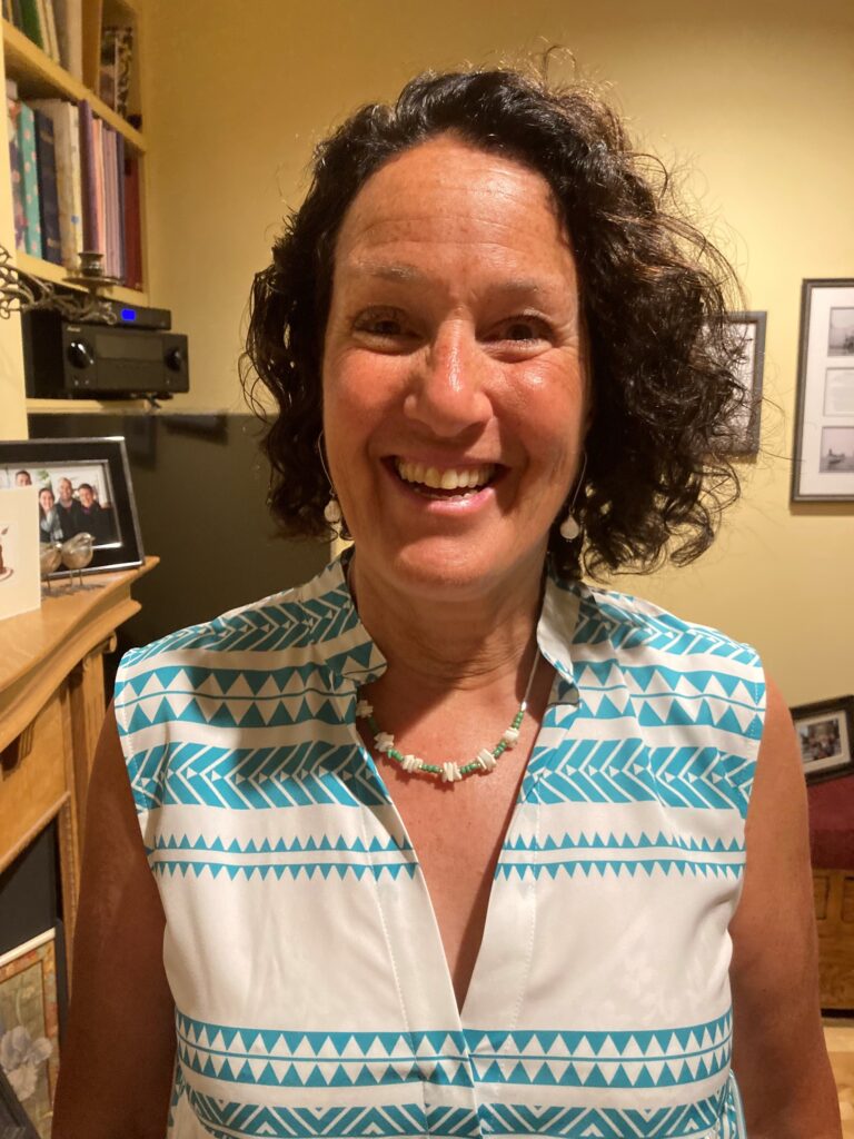 Marci Morris smiles for the camera, standing in her home office.